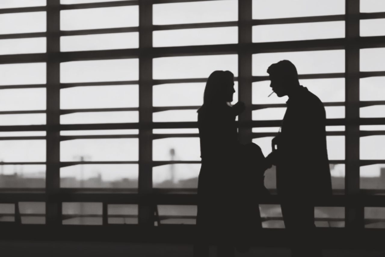 Silhouette man and woman standing in building