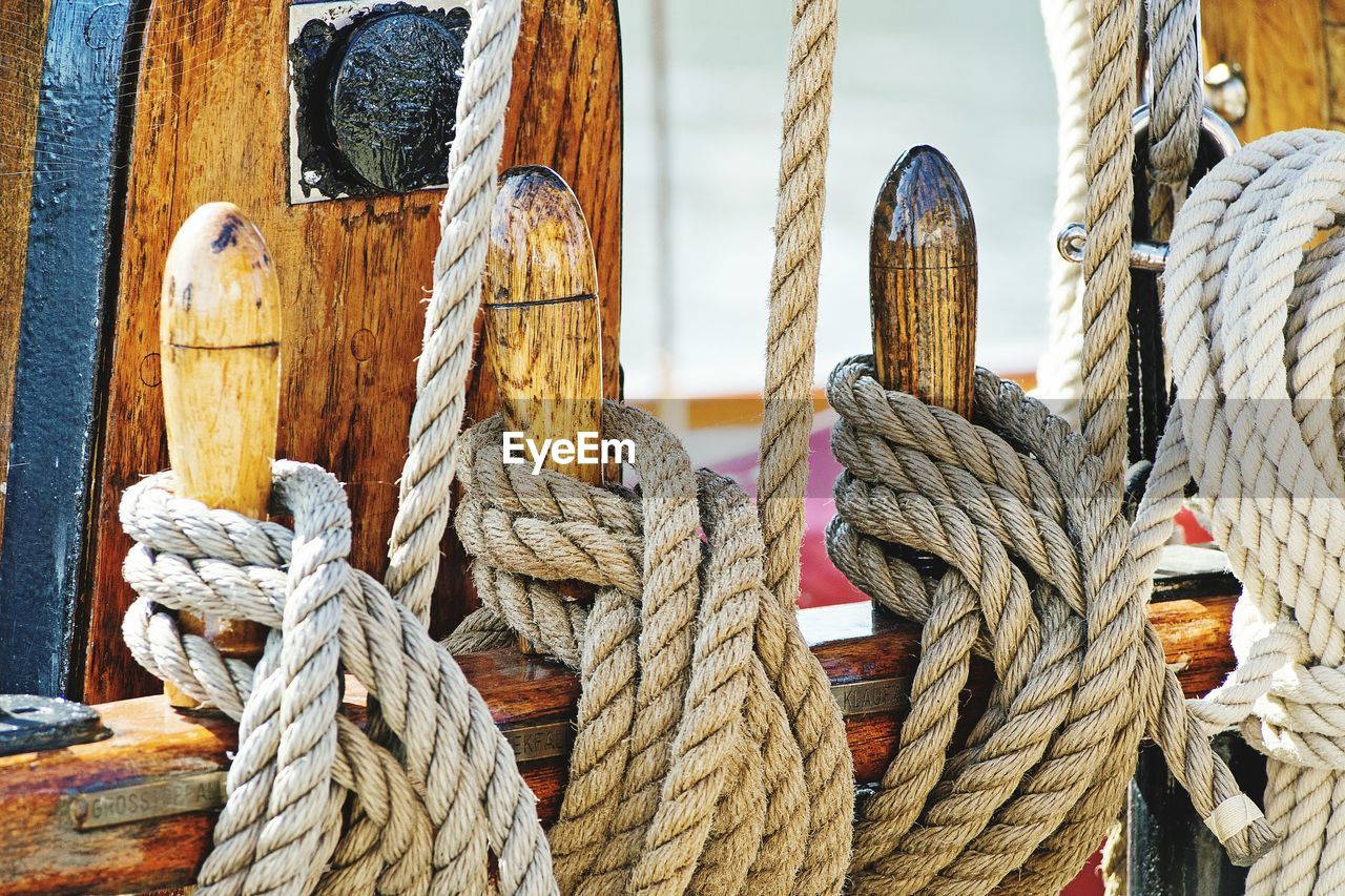 CLOSE-UP OF ROPE TIED ON WOODEN WALL