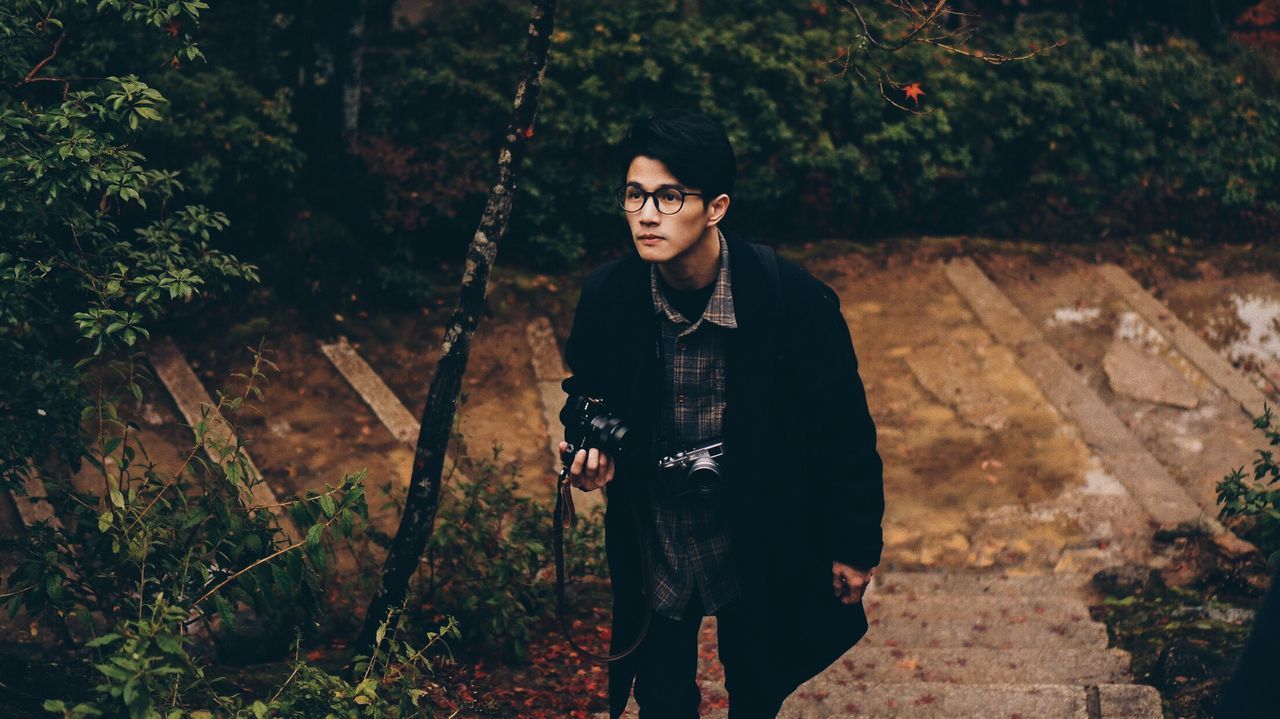 Young man looking away in forest