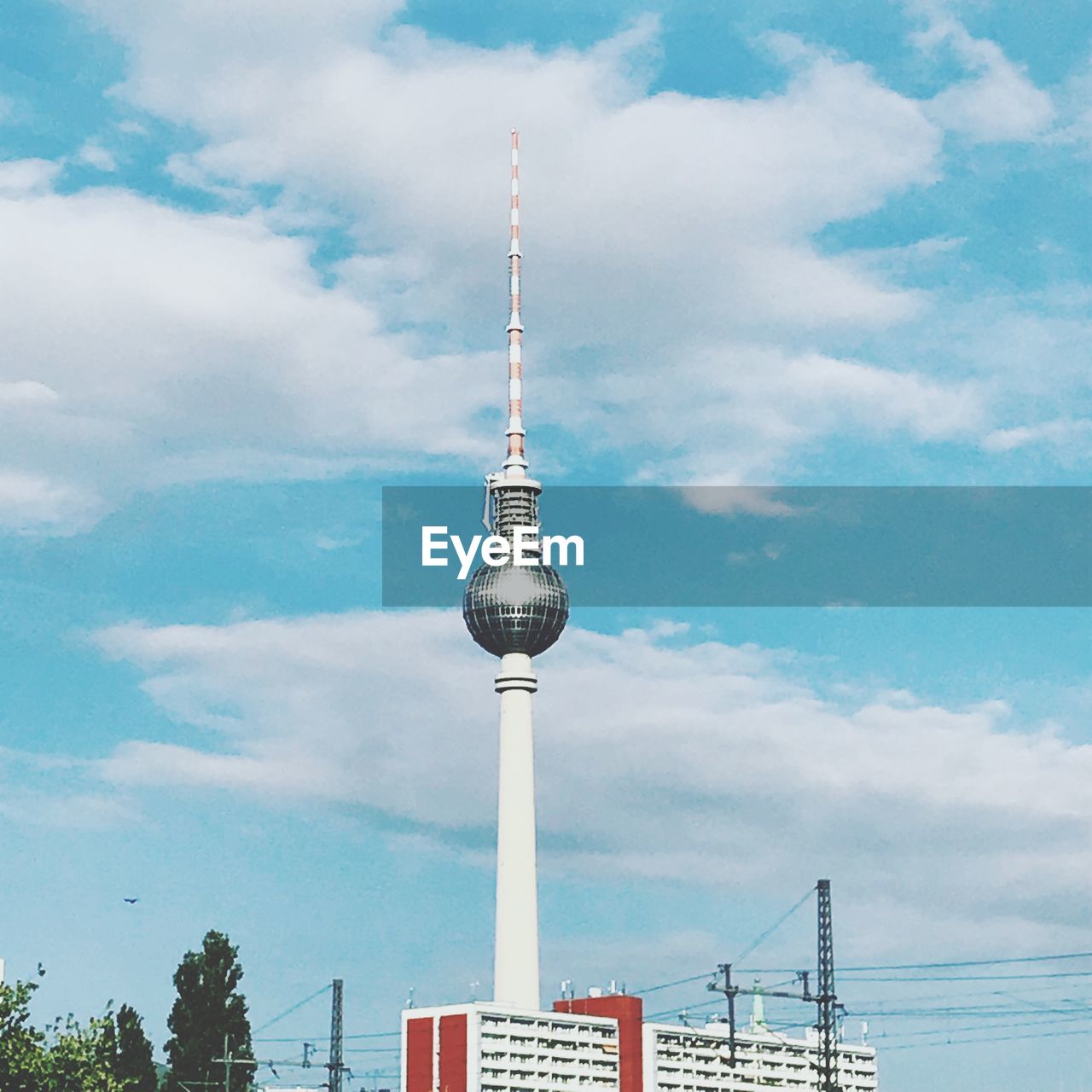 Low angle view of communications tower against cloudy sky