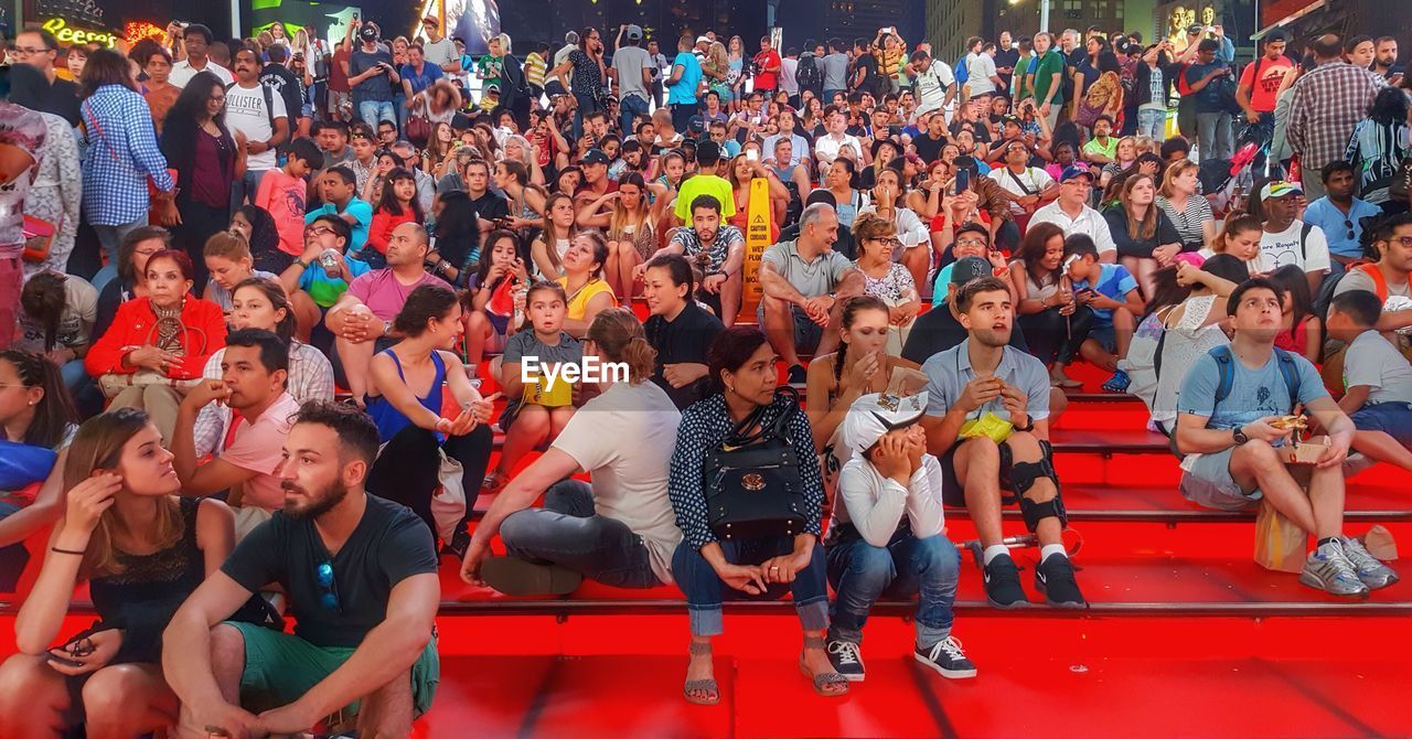 HIGH ANGLE VIEW OF PEOPLE SITTING ON WALL