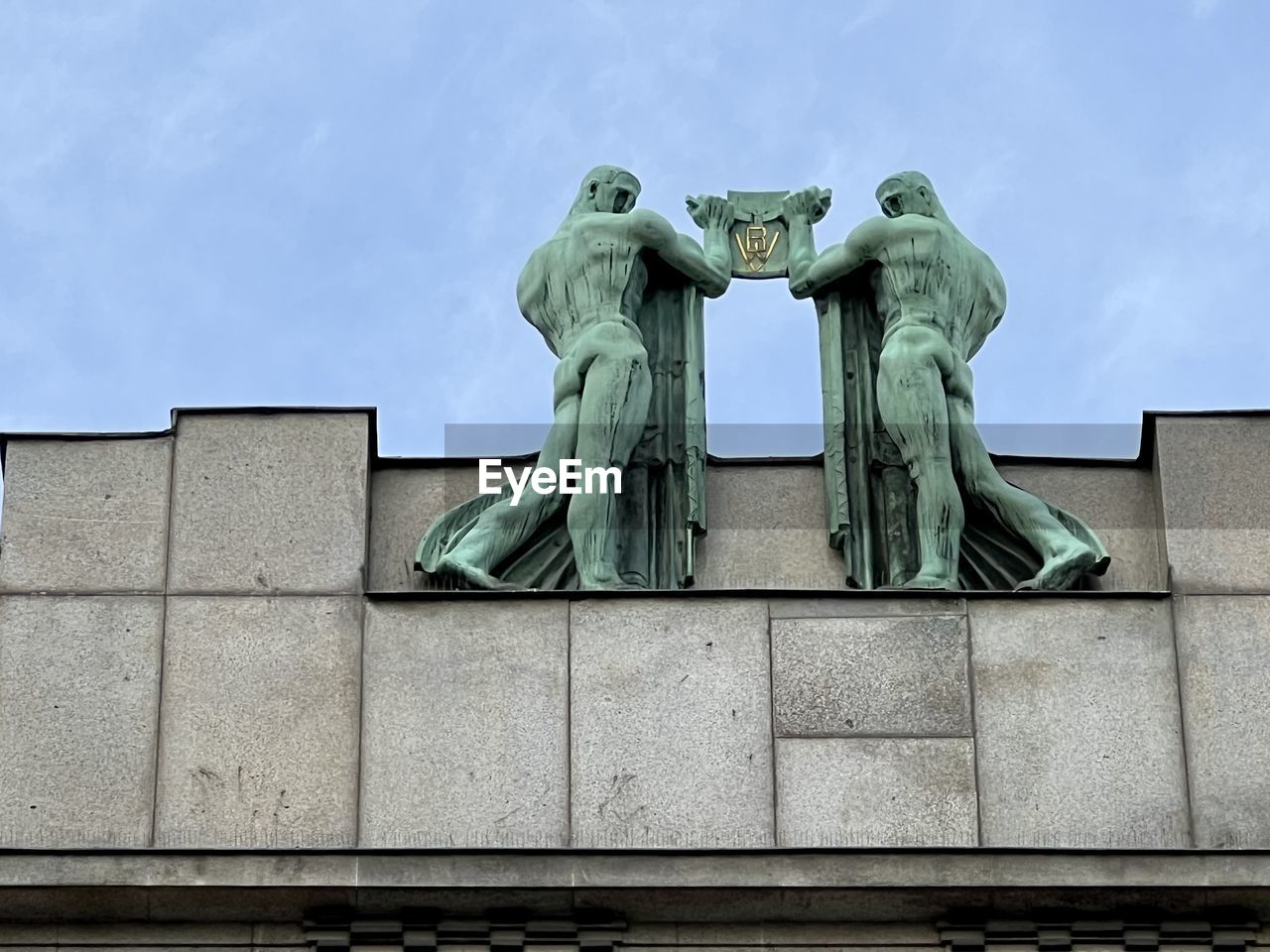 architecture, sculpture, statue, sky, monument, human representation, memorial, representation, no people, built structure, art, low angle view, building exterior, day, landmark, craft, green, creativity, male likeness, nature, cloud, history, the past, wall, outdoors, city, blue, travel destinations