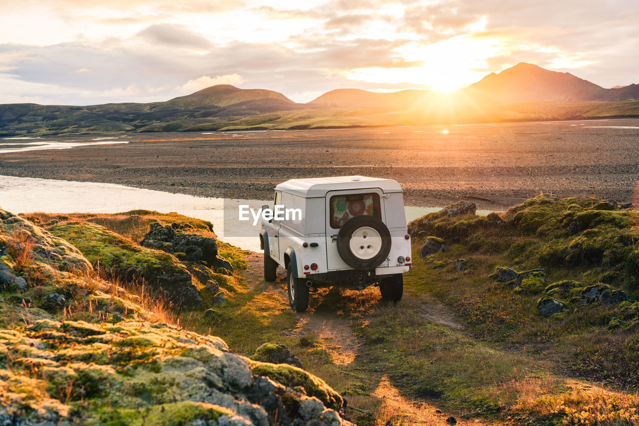 4x4 truck looks out over sunrise landscape in iceland