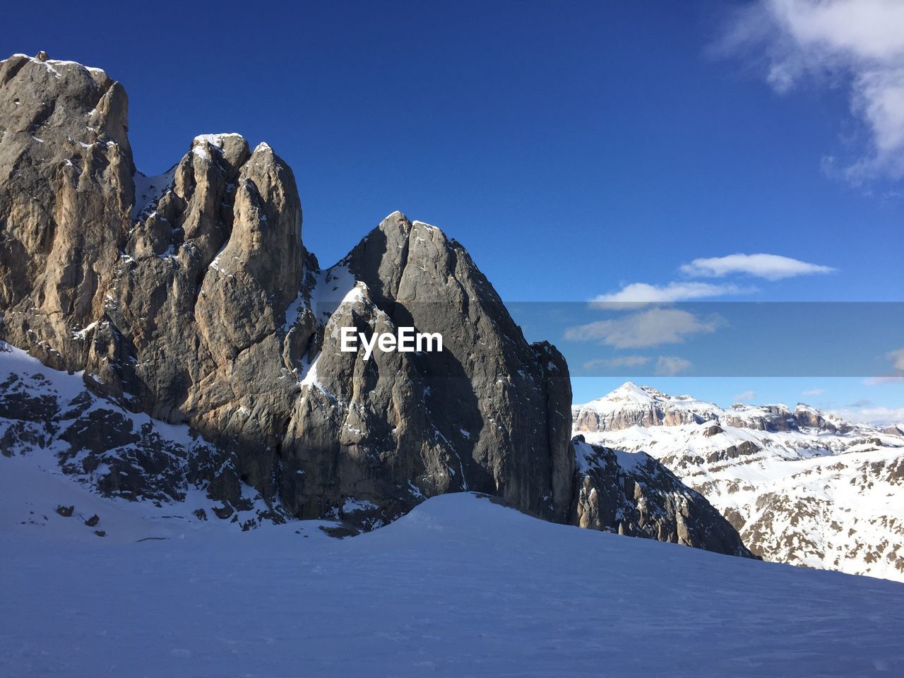 Scenic view of snowcapped mountains against blue sky