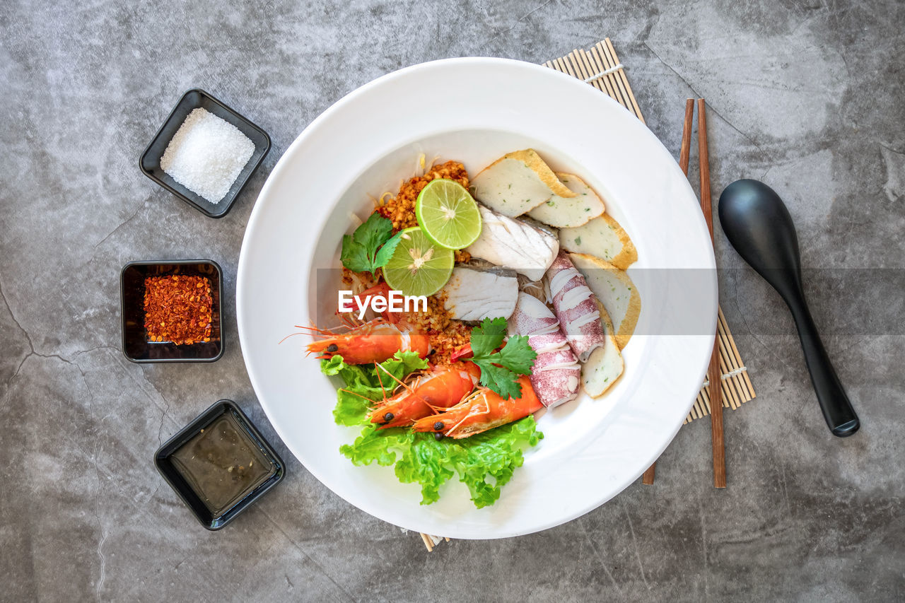 food and drink, food, healthy eating, vegetable, plate, wellbeing, freshness, dish, eating utensil, meal, kitchen utensil, high angle view, studio shot, fork, fruit, gray, crockery, meat, indoors, directly above, produce, herb, lunch, no people, wood, gray background, tableware, salad, table, bowl, household equipment, spice, dinner, gourmet, seafood, garnish, tomato, basil, knife, italian food, root vegetable, table knife, savory food, vegetarian food