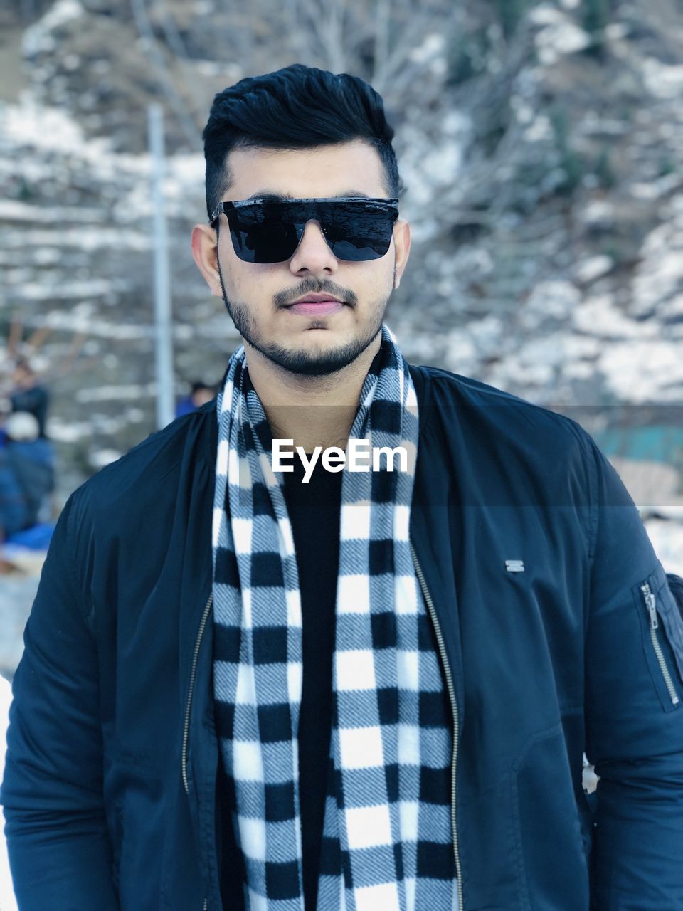 Portrait of young man wearing sunglasses standing outdoors