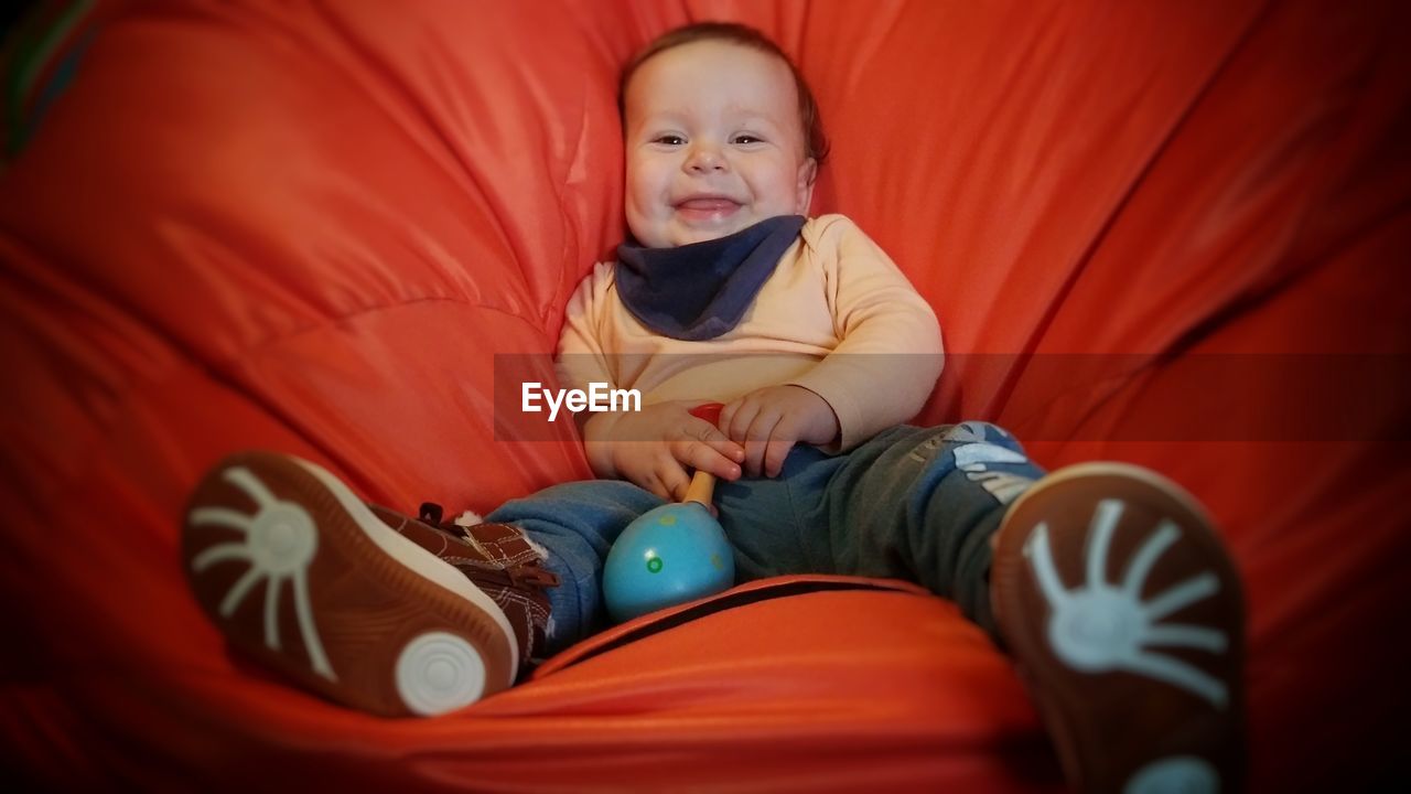 Portrait of cute baby boy lying on bean bag