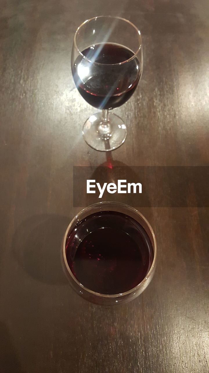 HIGH ANGLE VIEW OF WINE GLASS ON TABLE