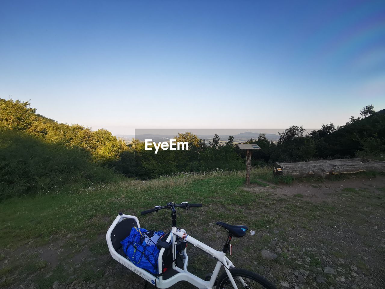 BICYCLE PARKED ON FIELD AGAINST CLEAR SKY