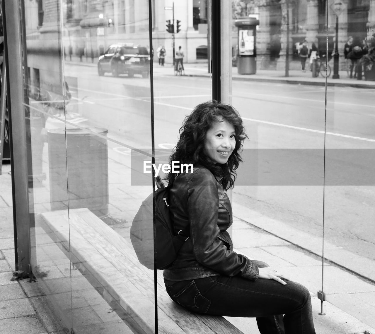 Portrait of woman sitting on glass window