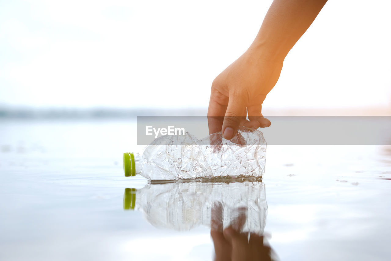 Close-up of hand picking plastic bottle