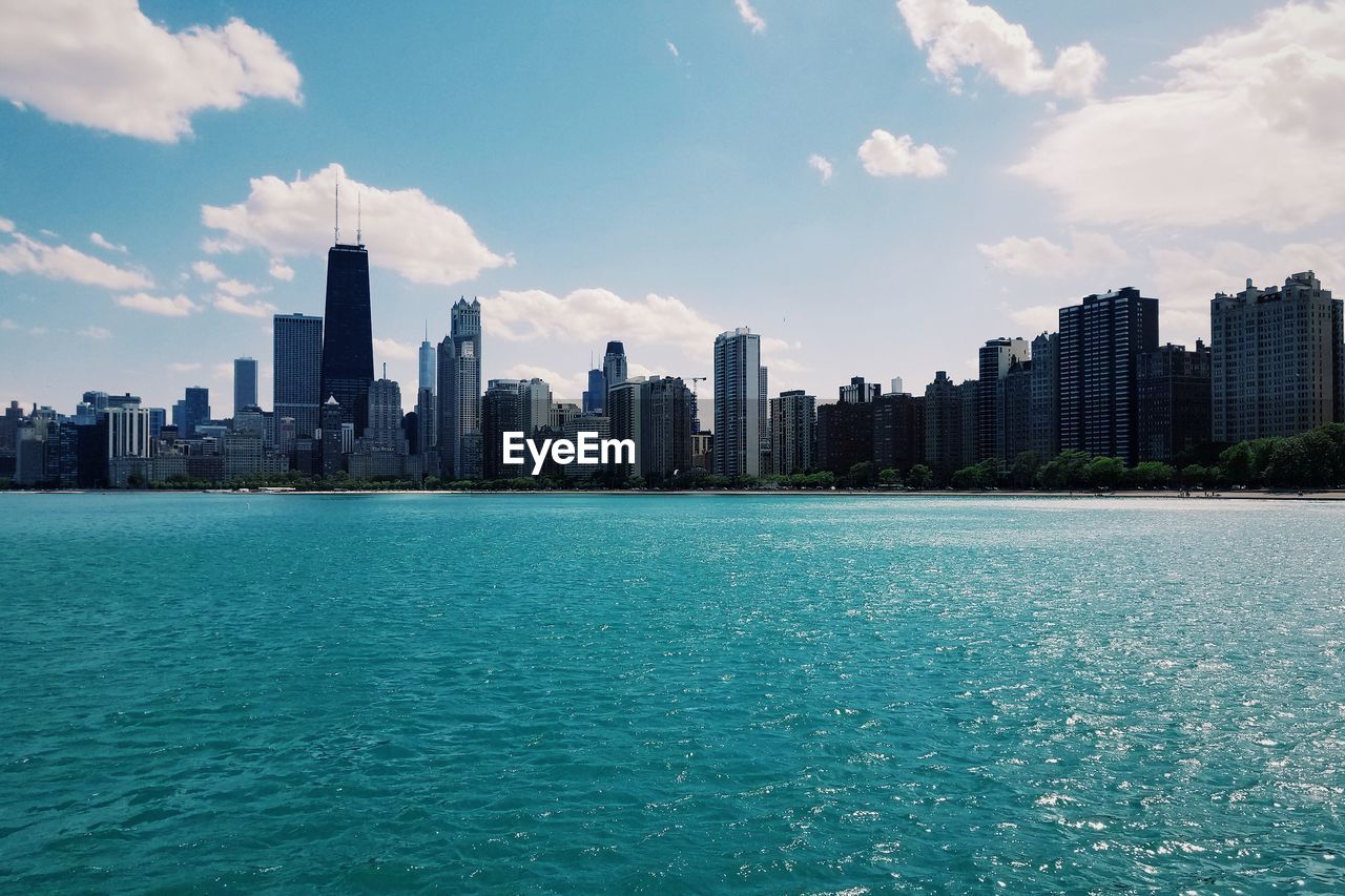 Lake with city in background against sky