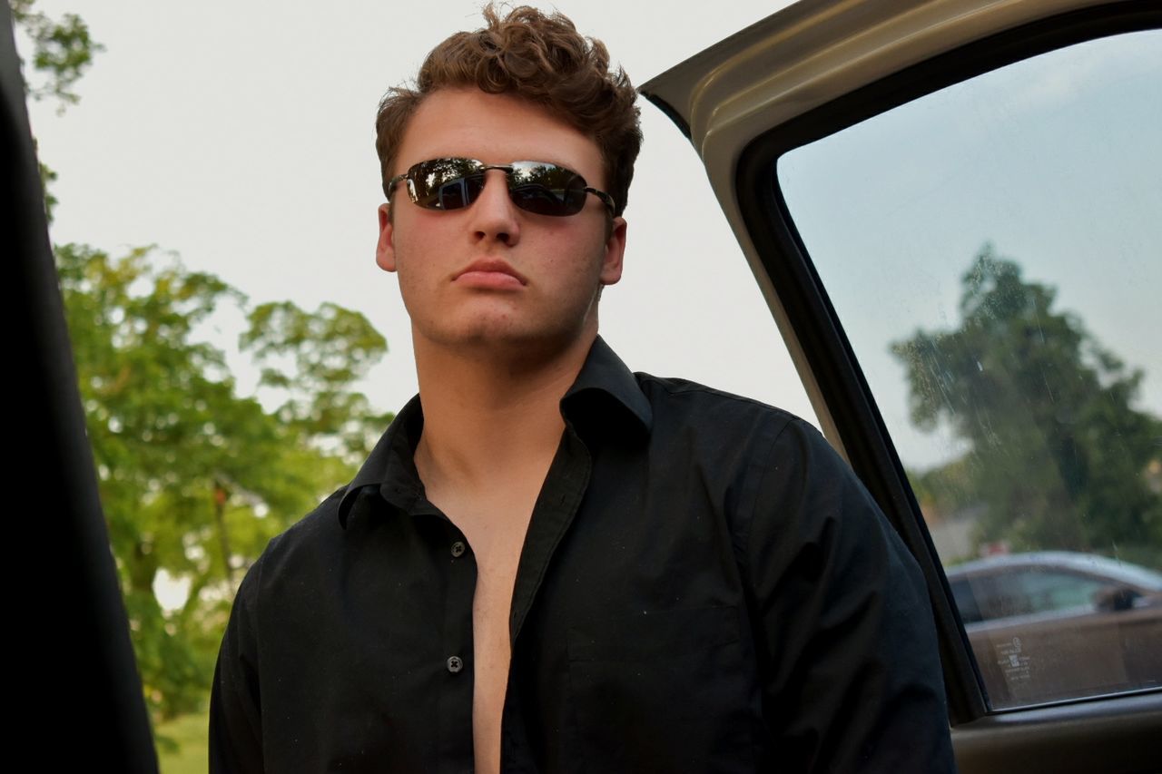 Low angle view of man standing by car door