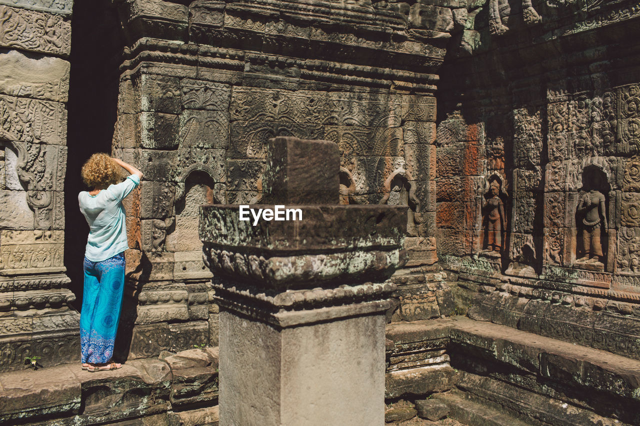 Rear view full length of woman standing outside temple 