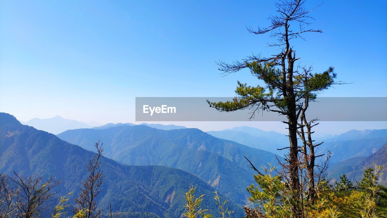 Scenic view of mountains against blue sky