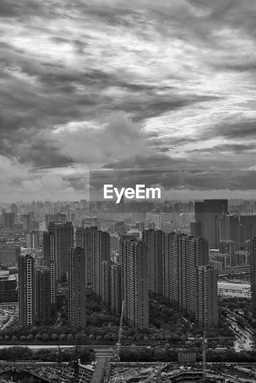 View of city buildings against cloudy sky