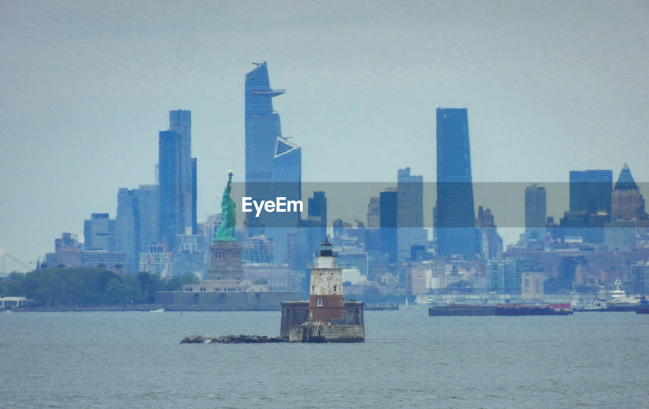 Scenic view of sea by buildings against sky