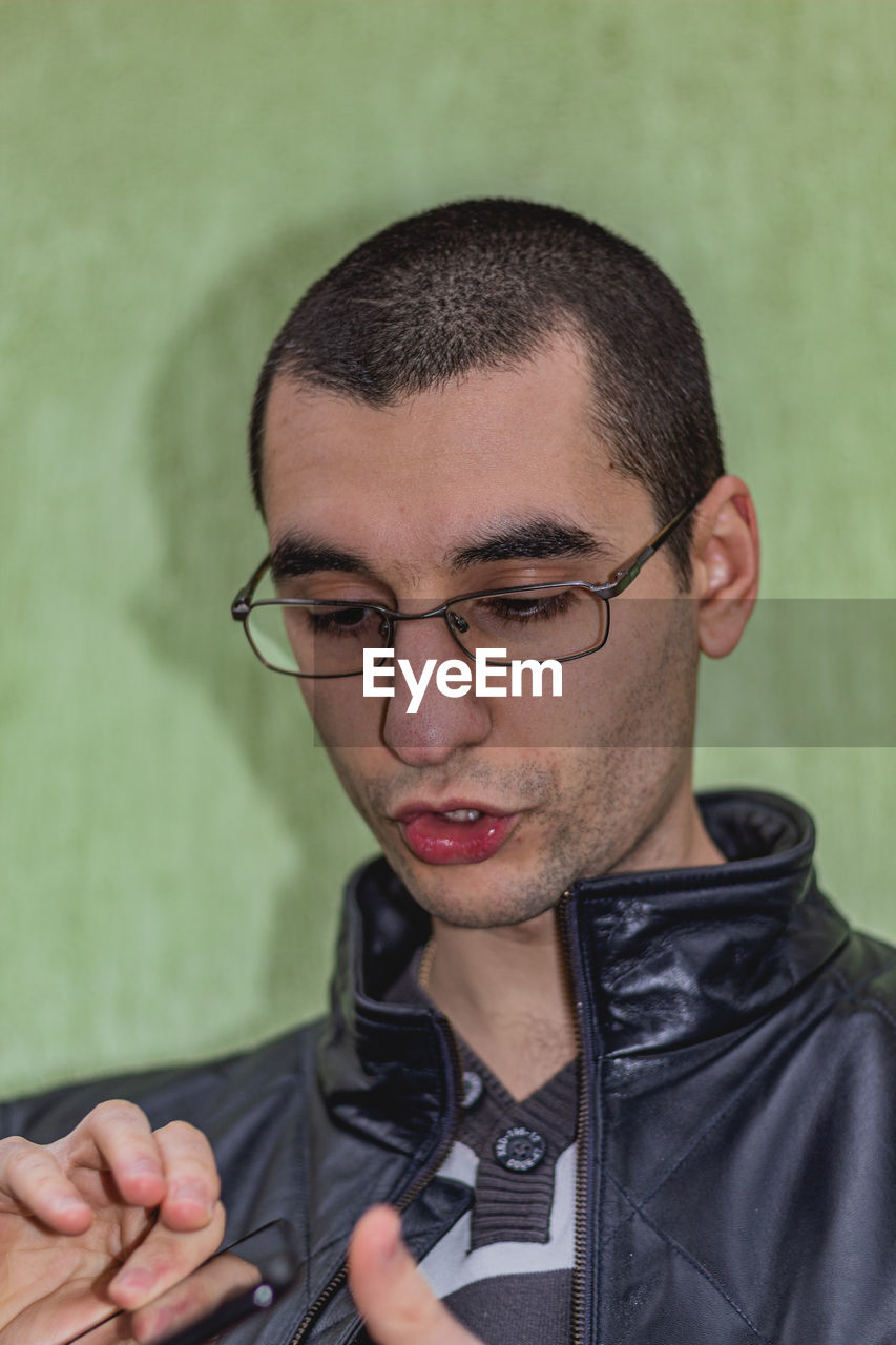 PORTRAIT OF YOUNG MAN WEARING EYEGLASSES