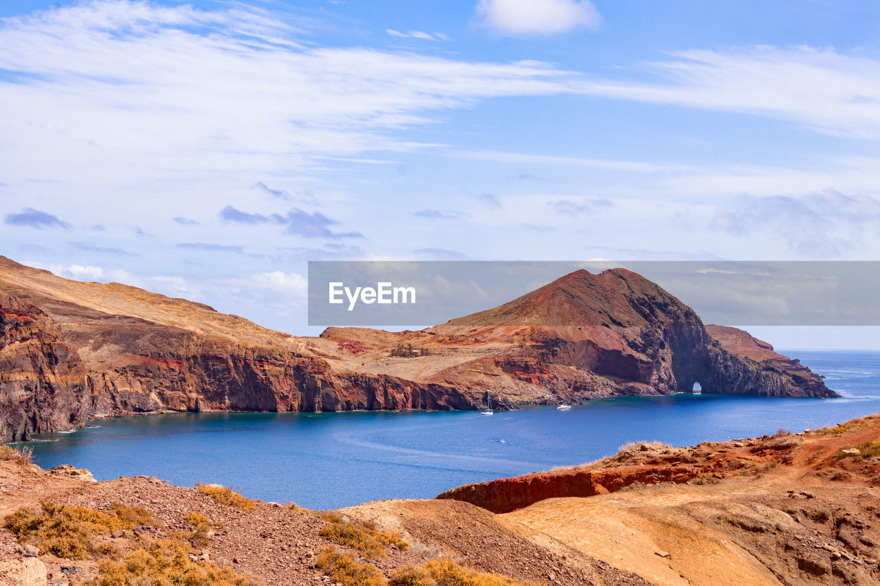 Scenic view of sea and mountains against sky