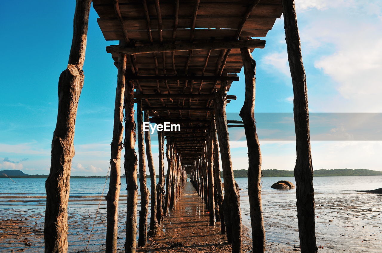 Wooden pier on sea against sky