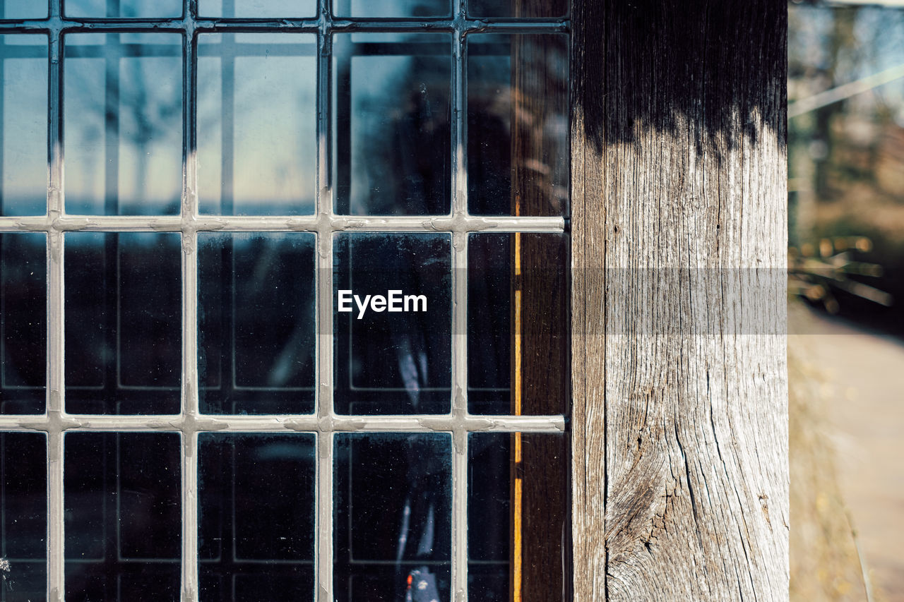 Close up of old window with metal window bars in wooden house