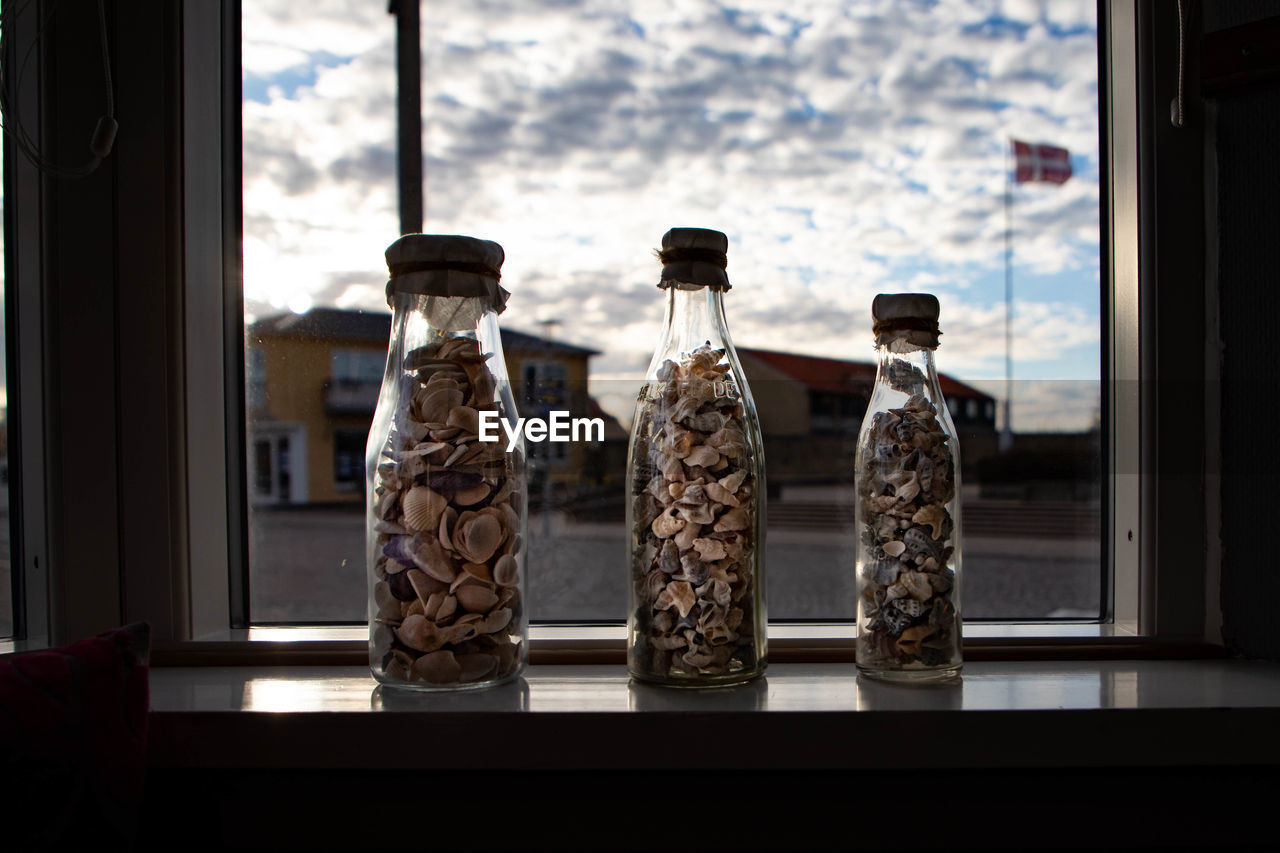 Sea shells in jar on window sill