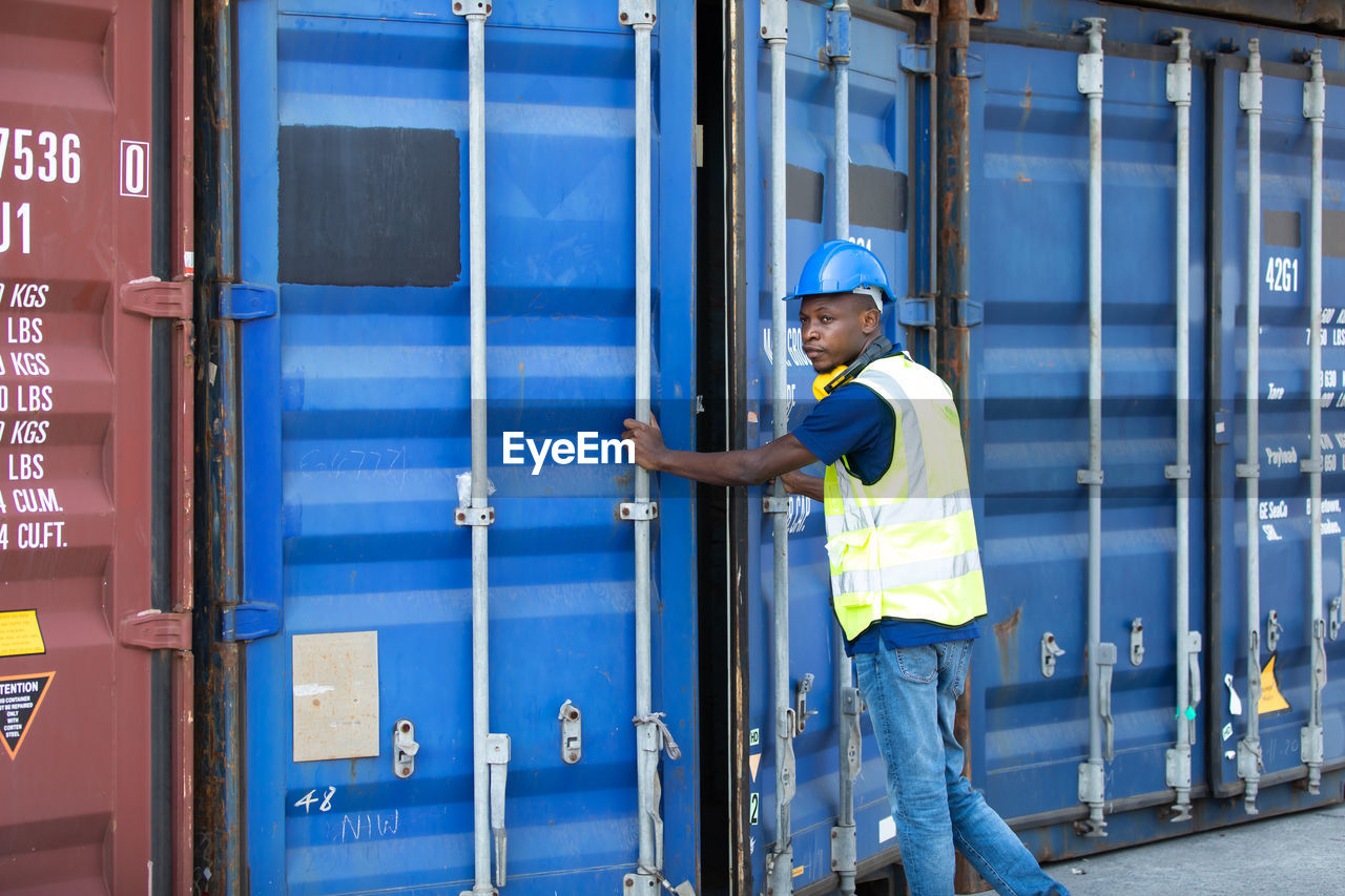 Rear view of manual worker closing cargo container