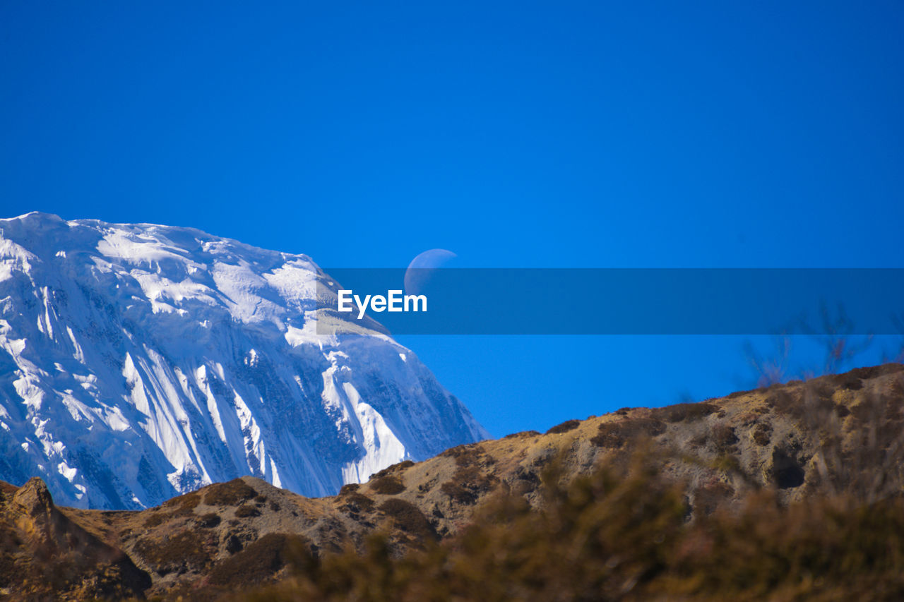 Scenic view of mountains against clear blue sky