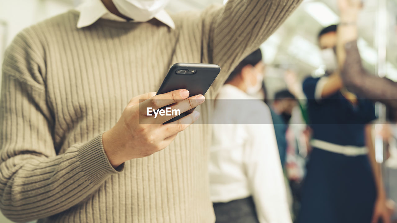 Midsection of man using mobile phone