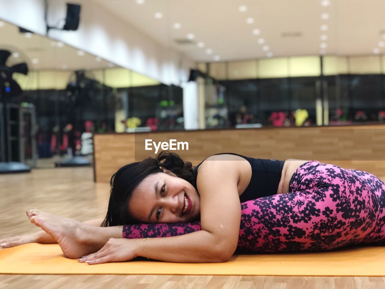 Side view portrait of smiling woman exercising in gym