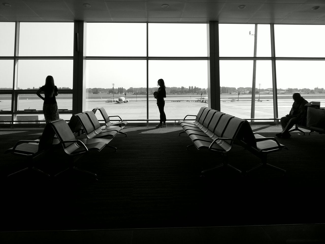 Silhouette people against window at airport