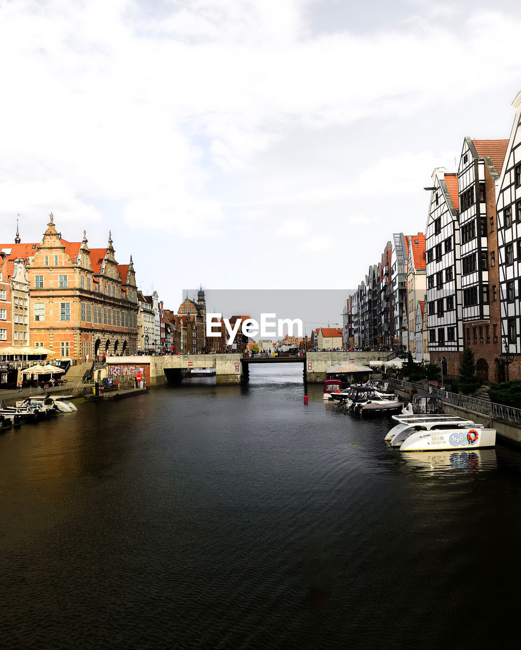 RIVER AMIDST BUILDINGS AGAINST SKY