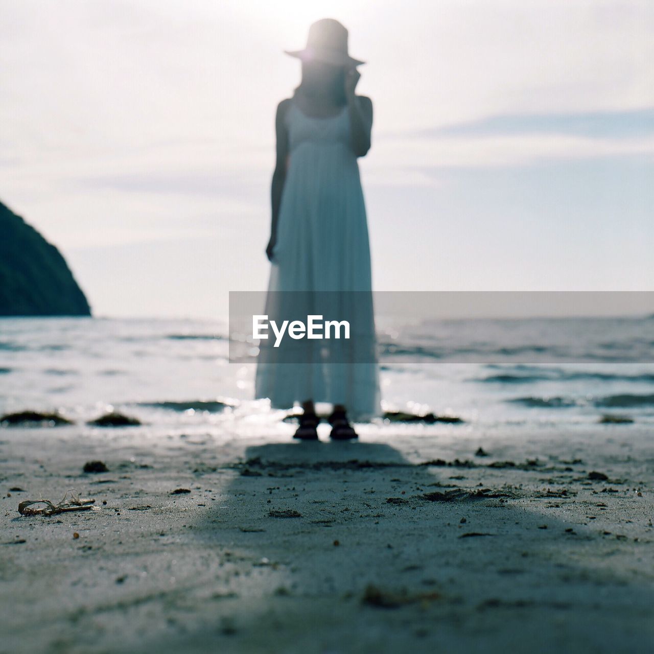 Full length of woman standing at beach against sky