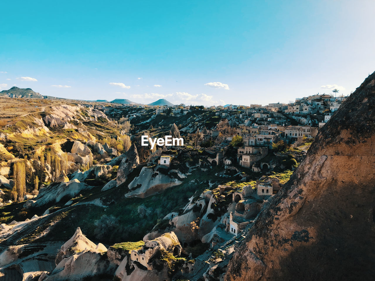 High angle view of city and mountains against blue sky