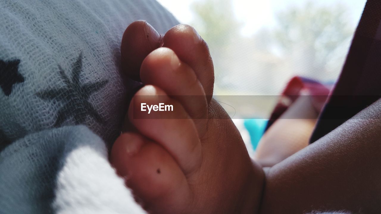 Close-up of baby foot on bed