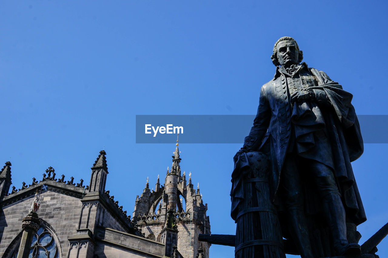 Low angle view of statue against clear blue sky