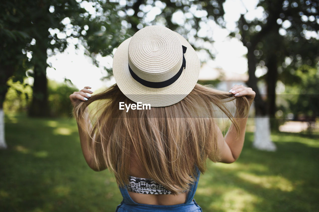 rear view of woman wearing hat while standing outdoors