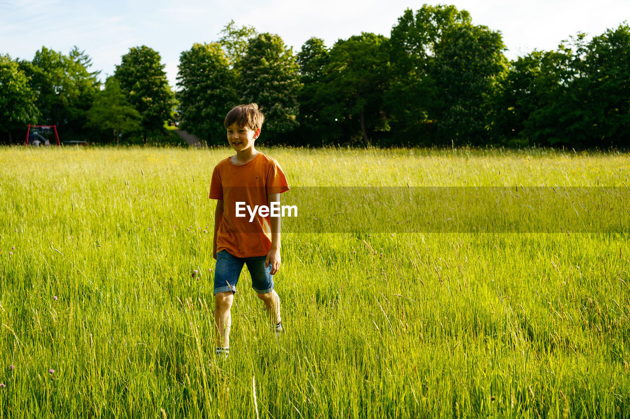 A boy runs through a summer field