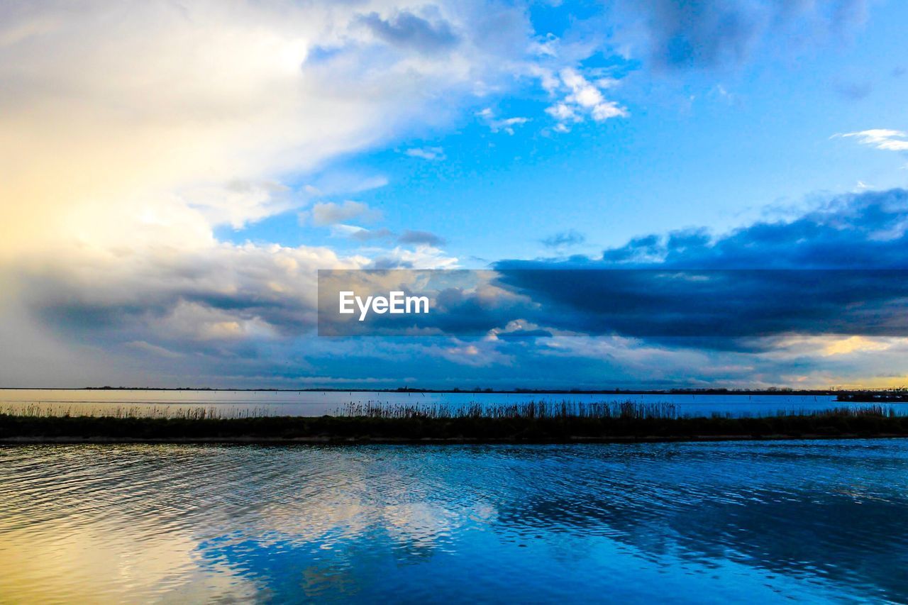 VIEW OF LAKE AGAINST CLOUDY SKY