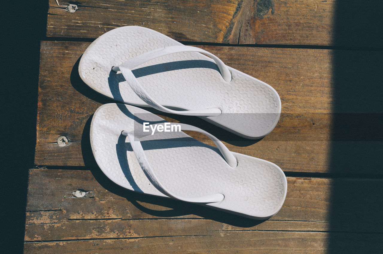 Directly above shot of flip-flops on boardwalk