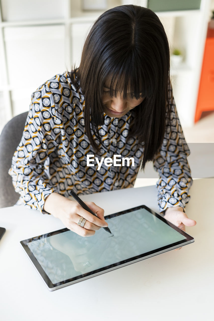 Female design professional using graphic tablet at desk