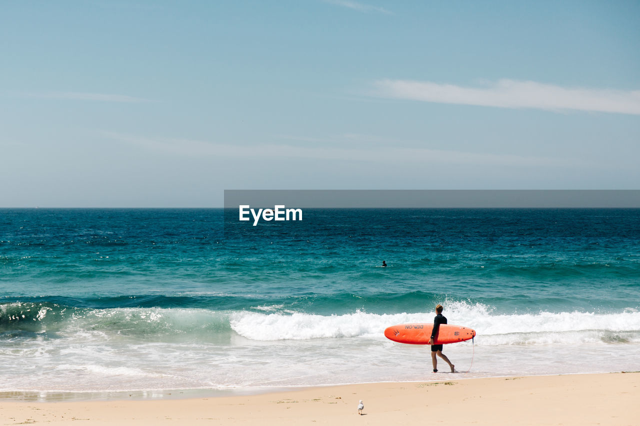 MAN SURFING ON BEACH