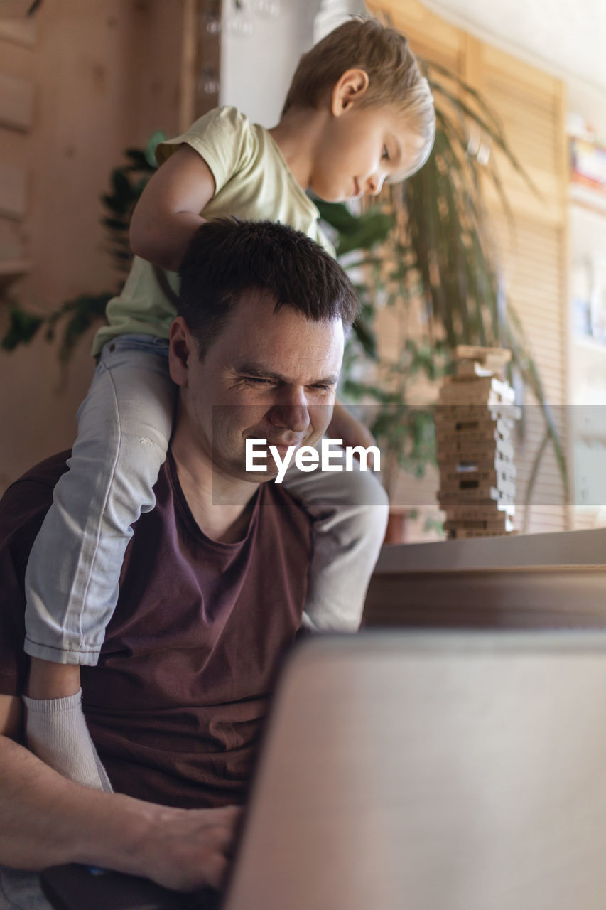 side view of boy using laptop while sitting at home