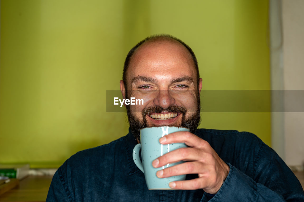 Portrait of man drinking coffee at home