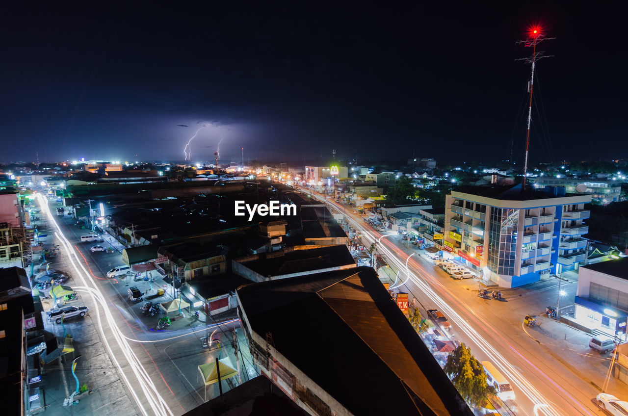 High angle view of illuminated street amidst buildings at night