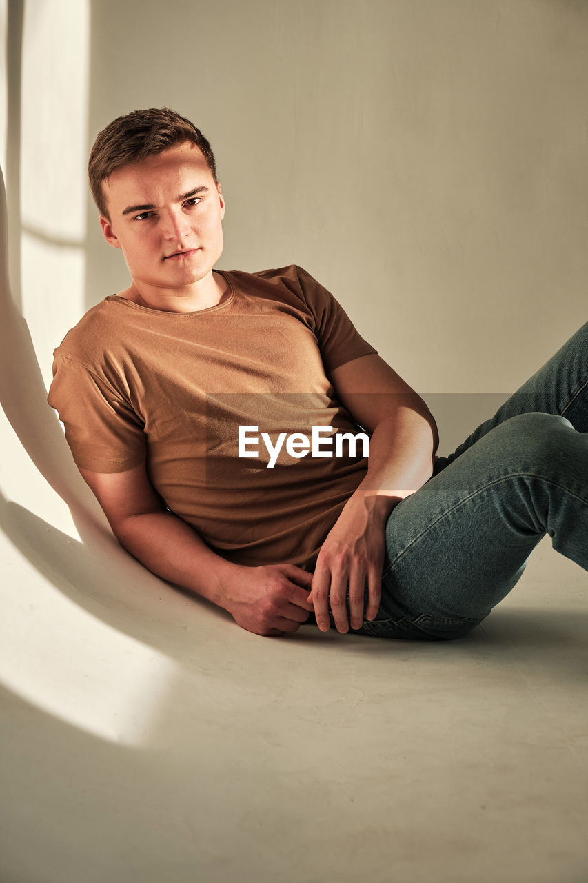 Handsome young man in t-shirt and jeans alone