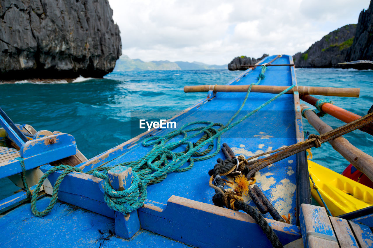 FISHING BOAT MOORED AT SEA AGAINST SKY