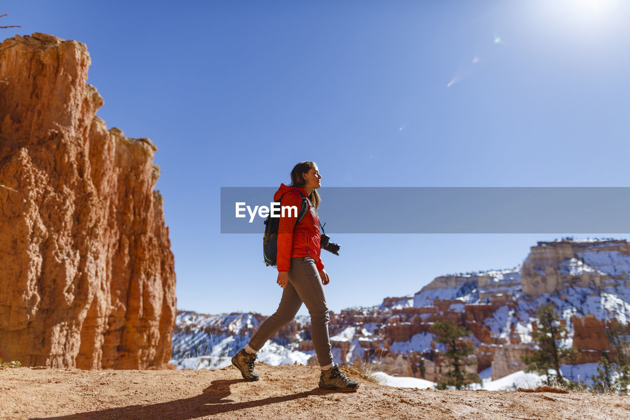 Hiker walking on mountain against clear sky at bryce canyon national park during winter