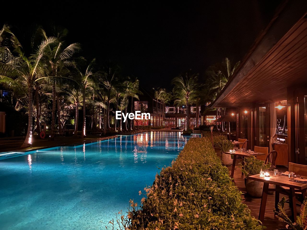 night, water, illuminated, swimming pool, resort, architecture, nature, tree, plant, travel destinations, estate, wealth, landscape lighting, luxury, no people, chair, built structure, holiday, building exterior, tourist resort, seat, tropical climate, outdoors, hotel, lighting equipment, evening, vacation, trip, building, palm tree, tranquility, travel, resort town