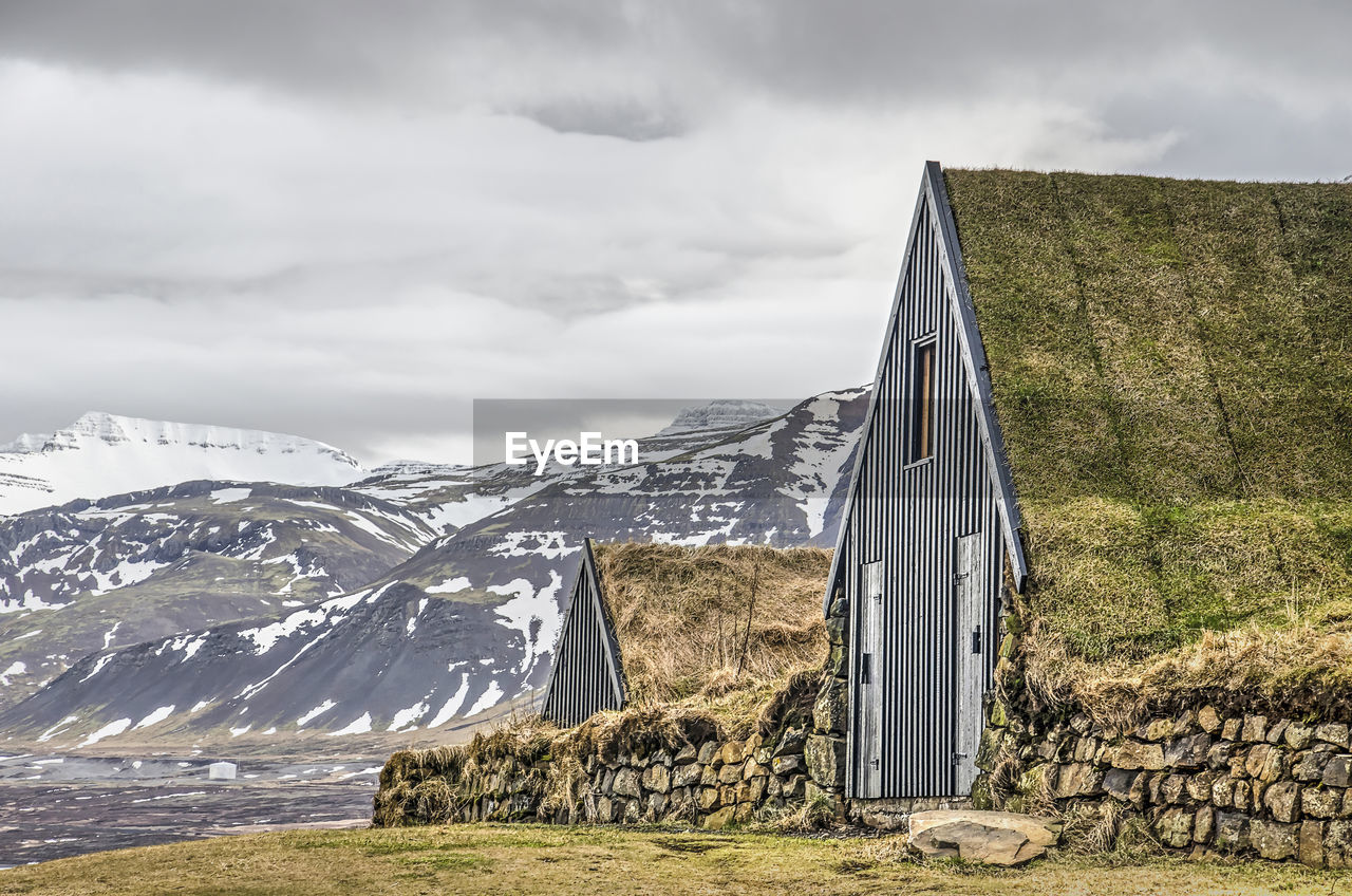 Built structure on snow covered land against sky